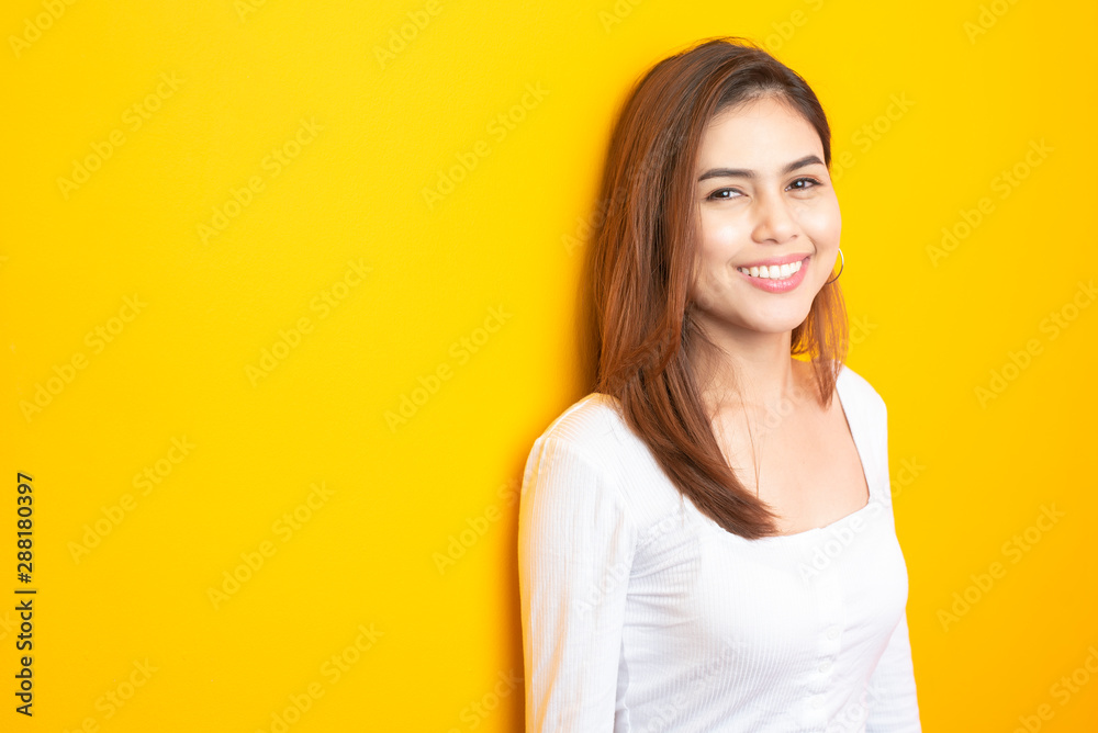 Beautiful university student is smiling on yellow background Beautiful university student is smiling on yellow background
