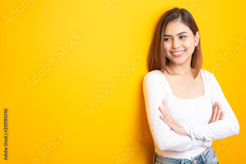 Beautiful university student is smiling on yellow background