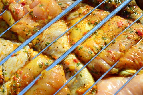 Marinated chicken legs on hot BBQ charcoal field grill photo