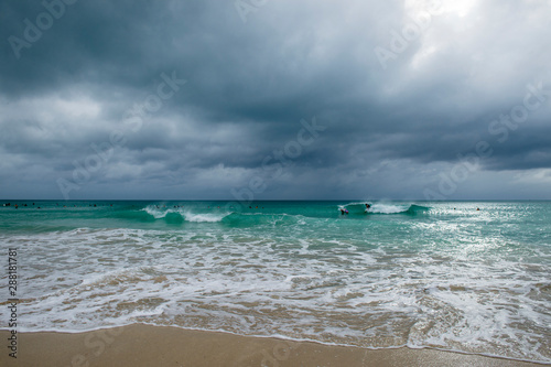 Принти на полотні Dramatic view of waves washing ashore under a dark storm clouds on a tropical be