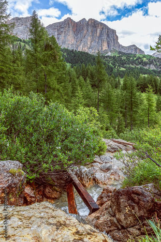 View of waterfall Pisciadu (Cascate del Pisciadù) and northern cliffs of Sella mountain group, Italian Dolomites, Corvara in Badia, Italy. Summer time photo