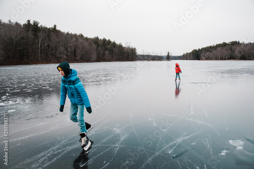 teenage boy skating on a frozen lake photo