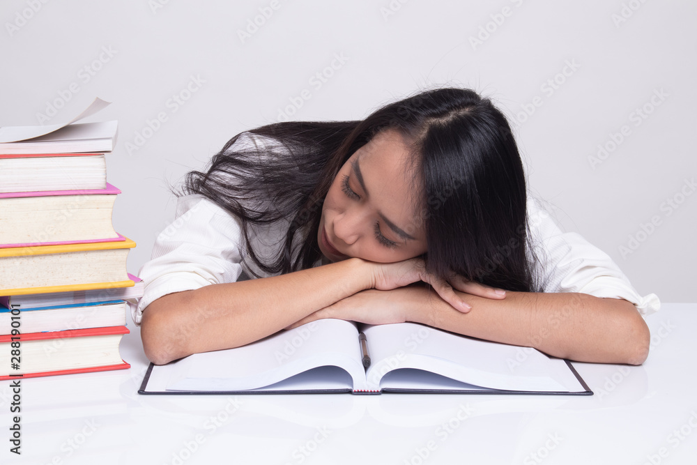 Exhausted Young Asian woman sleep with books on table. Exhausted Young Asian woman sleep with books on table.