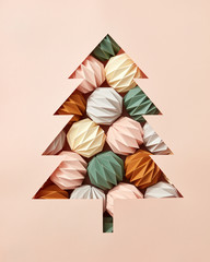 Handcraft composition of origami colored balls and a Christmas tree cut out of beige cardboard with copy space. Flat lay