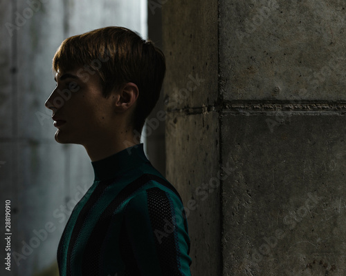 Face profile of young androgyne man in striped shirt