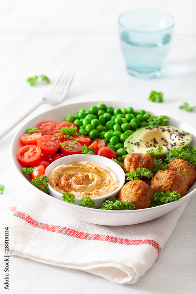 healthy vegan lunch bowl with falafel hummus tomato avocado peas