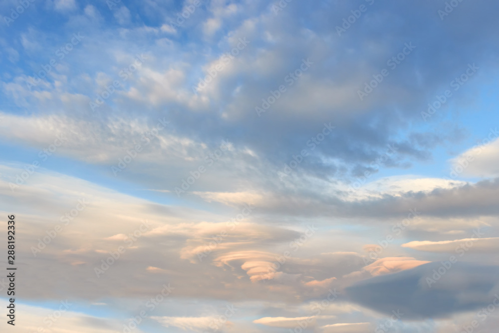 Landscape with lenticular clouds at sunset  blue sky