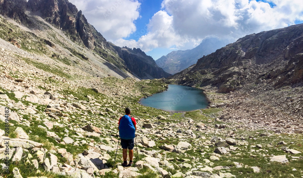 Hiker walking on a alpine terrain during the GR11 in the Pyrenees. Hiker walking on a alpine terrain during the GR11 in the Pyrenees.