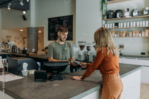 blonde woman paying in a cafe
