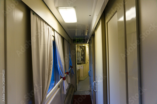 aisle in a russian train with the cabins next and windows on the other side photo