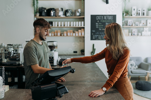 blonde woman paying in a cafe photo