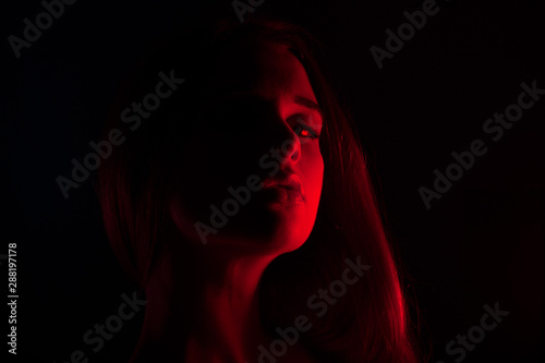 Young beautiful woman in lingerie posing in red back light