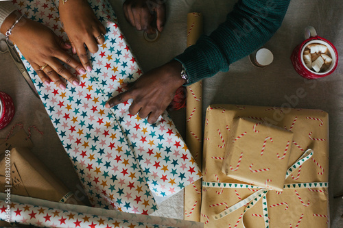 Black couple wrapping presents for Christmas