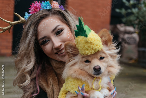 A girl in her twenties and her dog dressed up for halloween