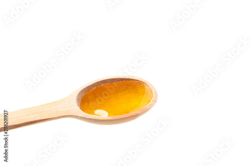 Wooden spoon with honey isolated on white background, closeup