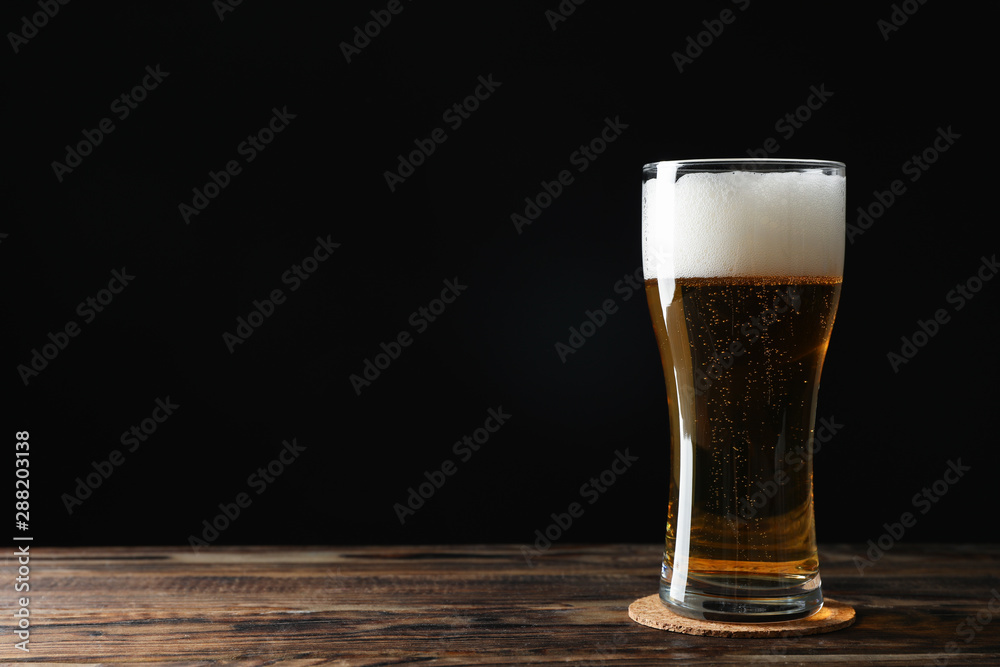 Mag with beer on wooden table, space for text