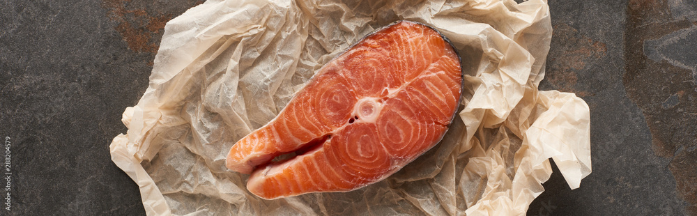 top view of raw salmon steak on bakery paper on stone table, panoramic shot top view of raw salmon steak on bakery paper on stone table, panoramic shot