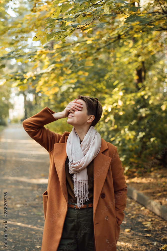 Stylish woman covering eyes in autumn park Stylish woman covering eyes in autumn park
