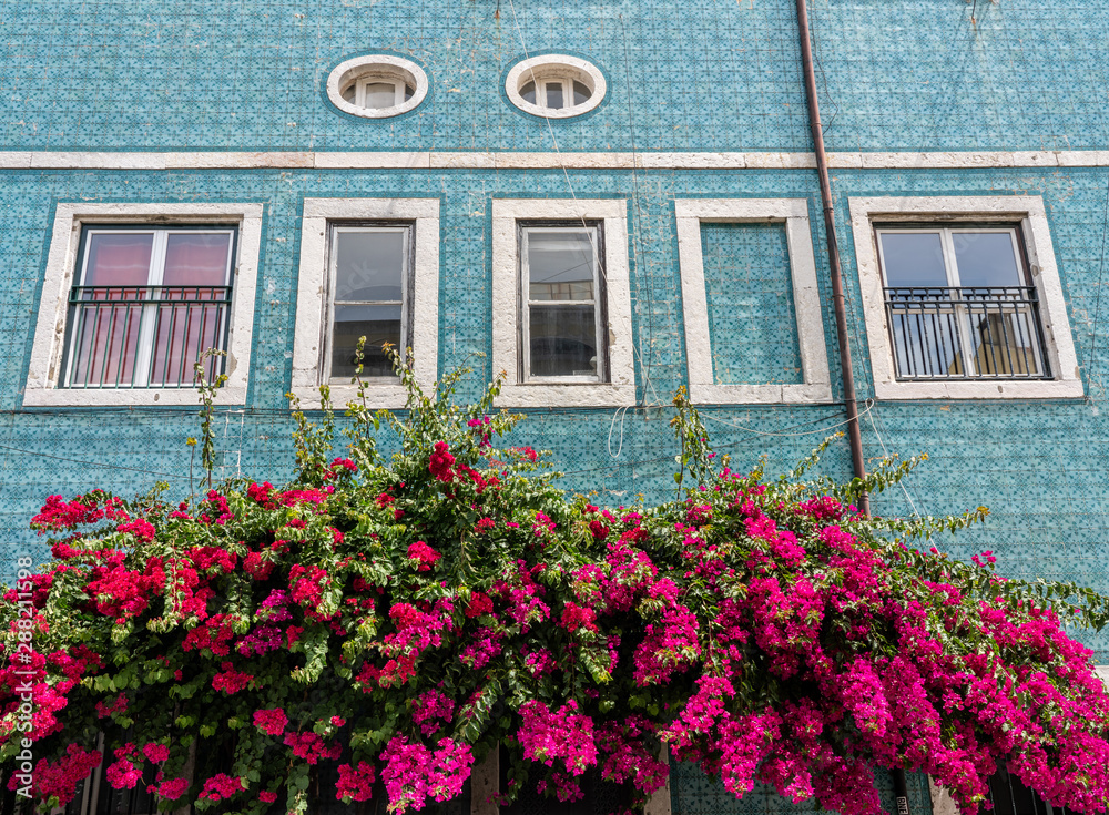 Decorative ceramic tiles on a large house with colorful flowers in Alfama district of Lisbon, Portugal