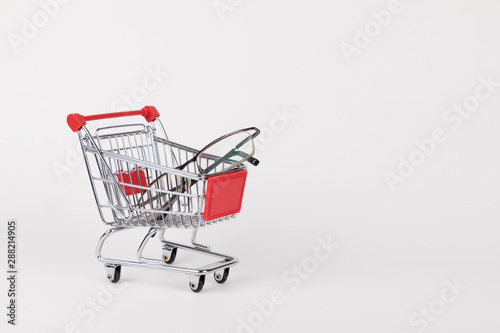 eyeglasses in shopping cart, isolated on white background