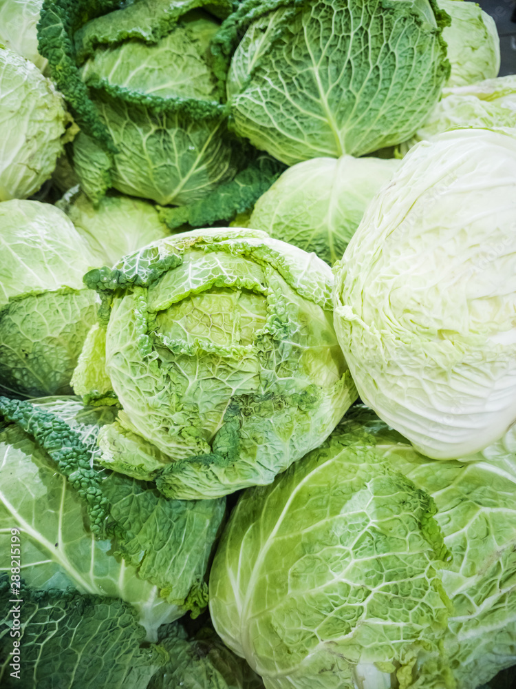 Fototapeta premium Fresh heads of cabbage close-up in the market. The concept of autumn harvest, organic products, discounts, trade.