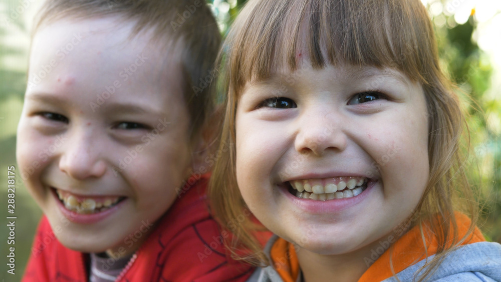 little funny boy and girl laugh in green garden close view little funny boy and girl laugh in green garden close view