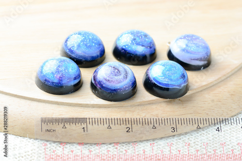 Create galaxy drink coasters using resin, glitter and pigment powders, handmade items. Suitable for keychains, necklace and pendant. photo