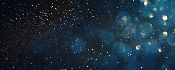 background of abstract glitter lights. blue, gold and black. de focused. banner