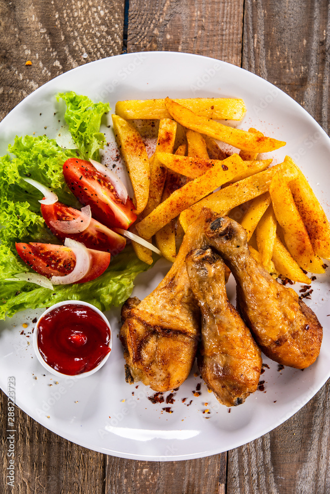Grilled chicken drumsticks with baked potatoes and vegetables Grilled chicken drumsticks with baked potatoes and vegetables
