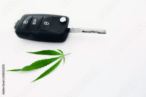 Cannabis leaf car keys on white background, concept driving under drug photo