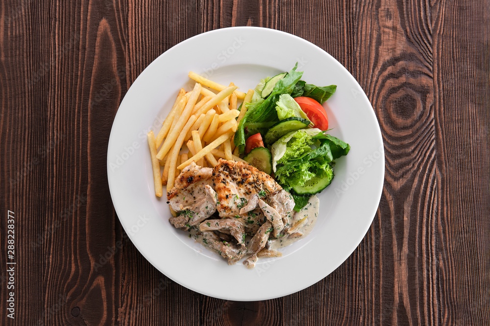 Grilled chicken fillet with oyster mushrooms, american fries and fresh vegetables Grilled chicken fillet with oyster mushrooms, american fries and fresh vegetables