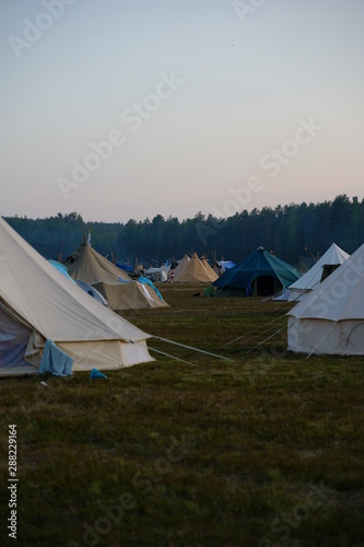 Tent on a field at nightfall with blue sky © Josef