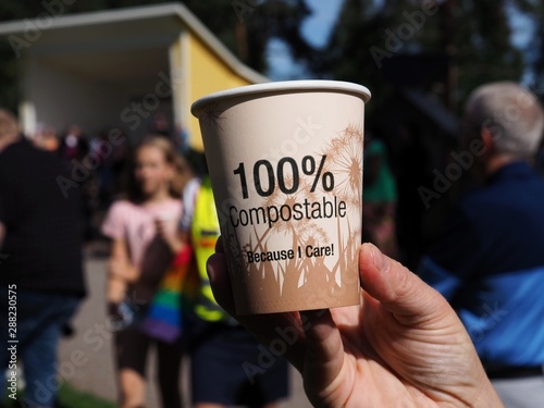 woman holding a compostable mug of coffee