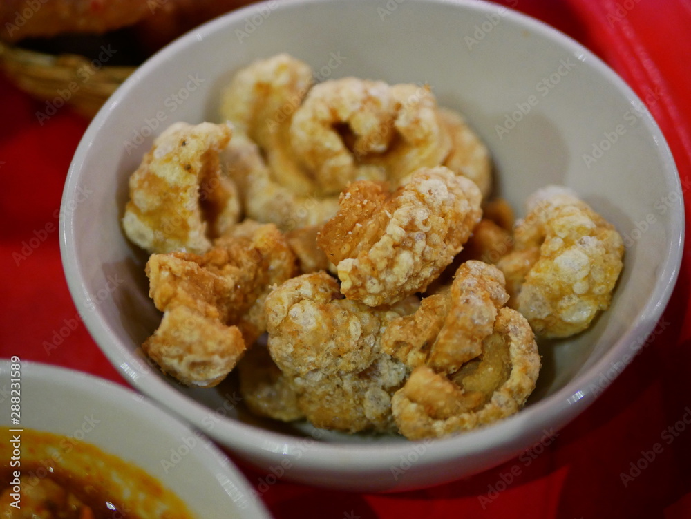 Closeup of brown crispy deep fried pork lard crackling (khaep mu) - famous and popular small side dish among the Thais Closeup of brown crispy deep fried pork lard crackling (khaep mu) - famous and popular small side dish among the Thais
