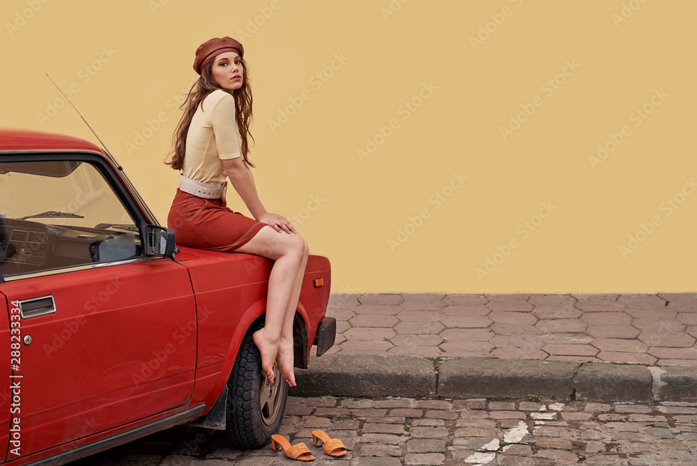Young beautiful girl dressed in retro vintage style in the old european city