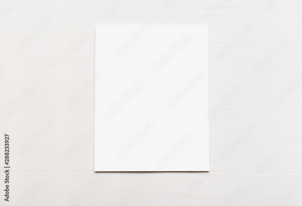 Blank sheet of paper on white fabric linen background Blank sheet of paper on white fabric linen background