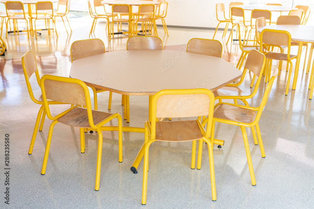 Empty school canteen yellow table and chairs