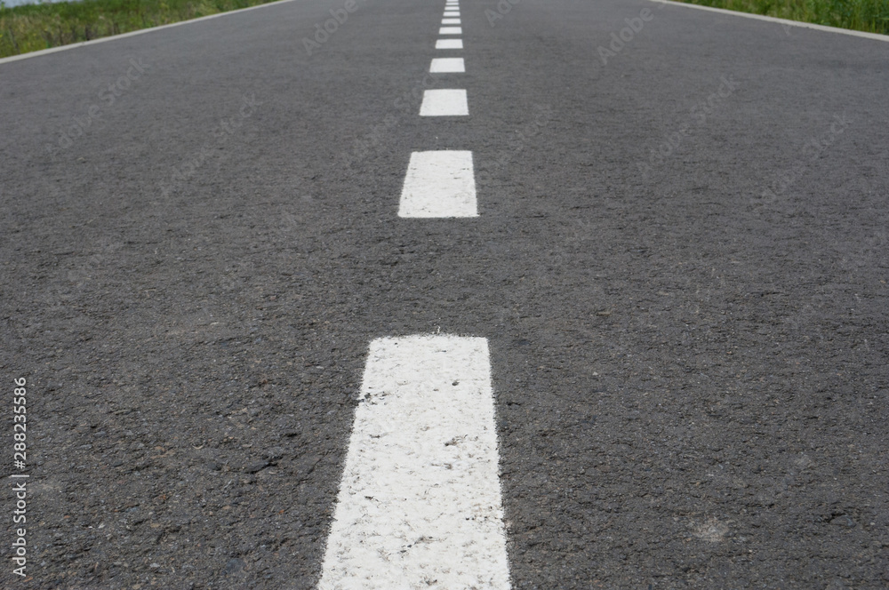 Dark asphalt road with marking lines. Tarmac texture