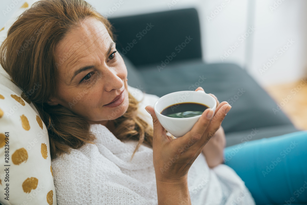 close up shot of beautiful middle aged woman drinking coffee or tea - obrazy, fototapety, plakaty 