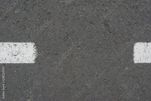 New asphalt texture with white dashed line © YanaKho