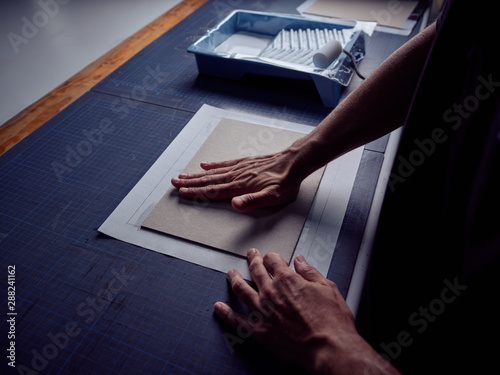 Bookbinder imposing fabric on cover for book photo