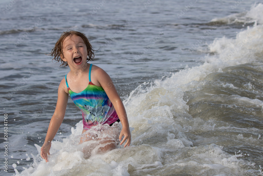 Fototapeta premium Young girl having fun in the ocean