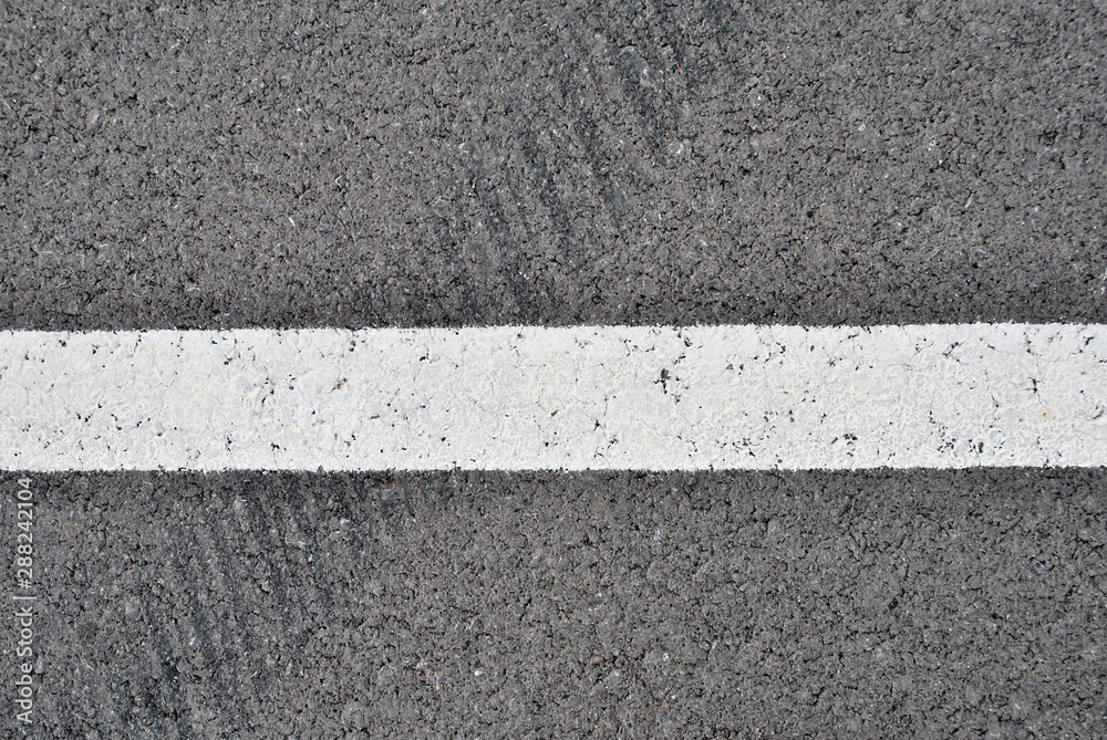 Fototapeta premium Asphalt texture with white line and tire marks . Top view