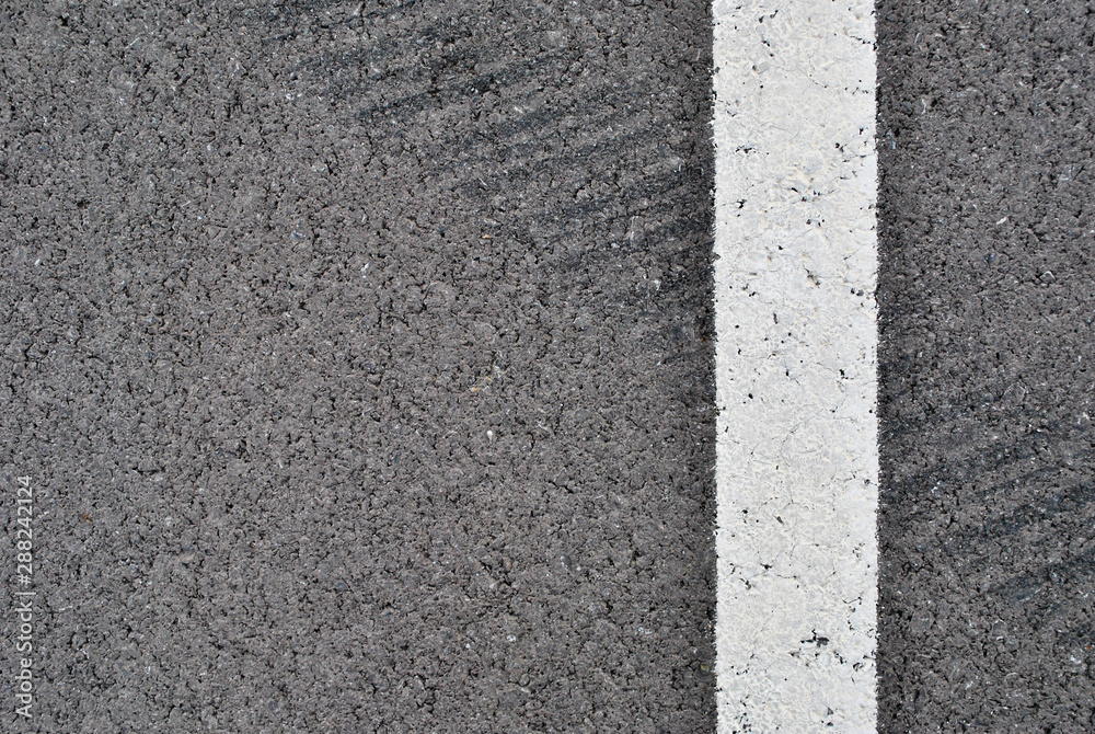 Fototapeta premium Asphalt texture with white line and tire marks . Top view