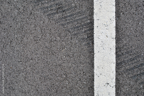 Asphalt texture with white line and tire marks . Top view