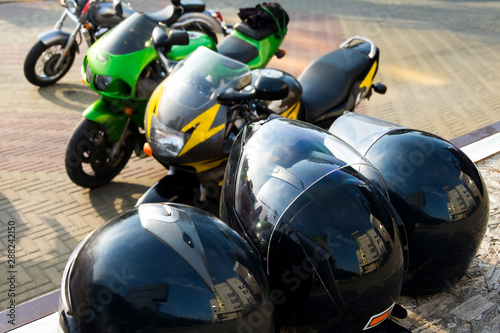 Safety helmets on the background of powerful motorcycles Kawasaki and Honda.