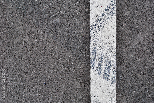 Asphalt texture with white line and tire marks . Top view
