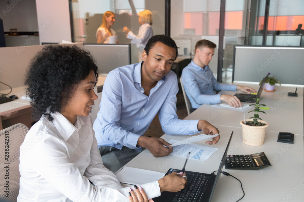 Black male supervisor analyze female trainee work at workplace