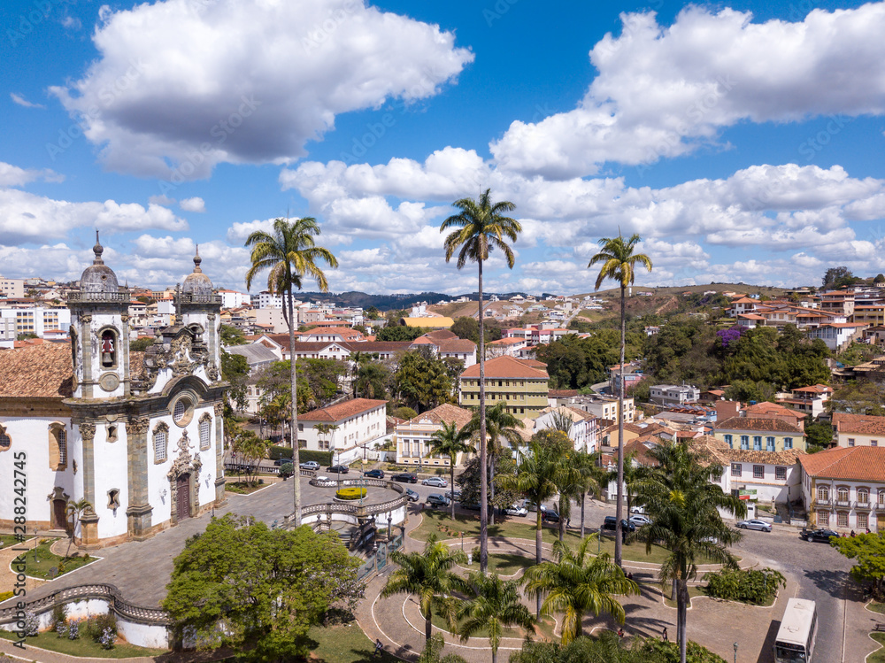 Obraz premium Drone aerial view of Sao Joao del Rei city, Minas Gerais, Brazil with church of Sao Francisco de Assis in sunny summer day. Baroque catholic heritage built with the artist Aleijadinho.