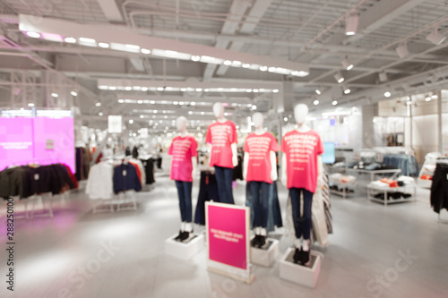 Sale and seasonal change of collection. Blurred View of fashionable clothing store in shopping center. Led lighting on the ceiling. Fire system and air conditioning system in retail shop.